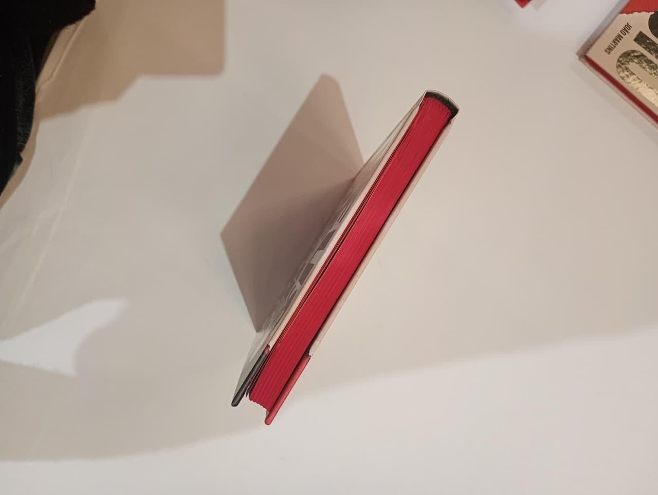 Lateral do livro mostrando as bordas das páginas pintadas de vermelho